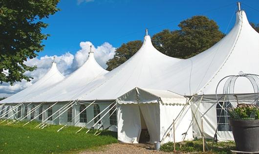 tall green portable restrooms assembled at a music festival, contributing to an organized and sanitary environment for guests in West Point